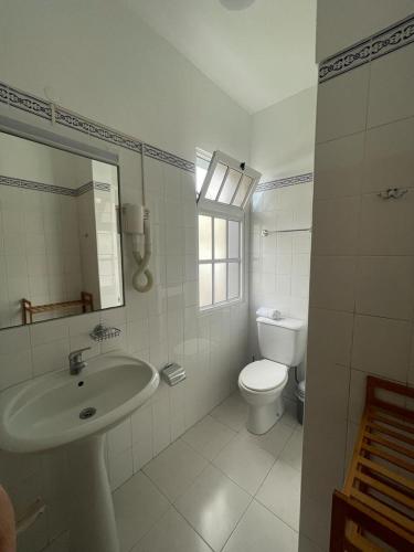 a white bathroom with a sink and a toilet at Valhalla Panorama in Funchal