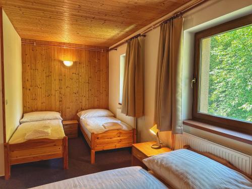 a room with two beds and a window at Penzion Peklo in Jeseník