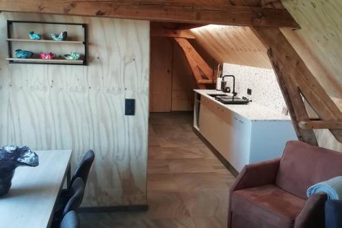 een keuken met een bank en een wastafel in de kamer bij Dreve 14 - bovenverdieping in Staden