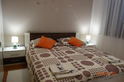um quarto com uma cama grande com almofadas cor-de-laranja e castanha em Apartman Stella em Fasana