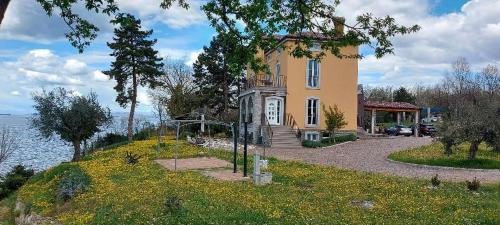 a house on a hill next to a body of water at Apartment Trieste M&M in Muggia