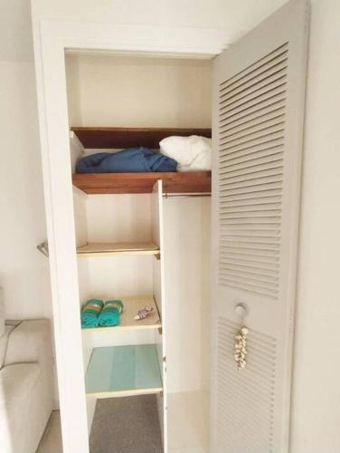 - un dressing avec une porte blanche et des étagères dans l'établissement Charmant Mazet à 250m de la Plage San Peire aux Issambres, à Saint-Peïre-sur-Mer
