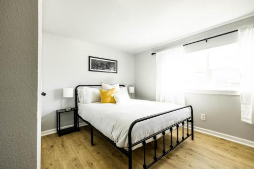 - une chambre avec un lit doté de draps blancs et d'oreillers jaunes dans l'établissement The Hive - Downtown Stephenville, à Stephenville