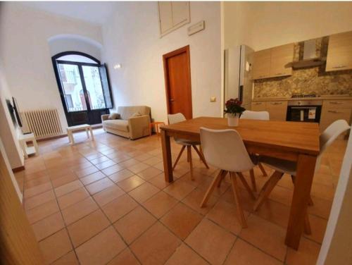 cocina y sala de estar con mesa de madera y sillas en Stanza privata nel cuore del barocco ragusano, en Ragusa