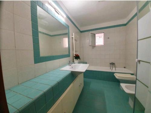 y baño con 2 lavabos, espejo y bañera. en Stanza privata nel cuore del barocco ragusano, en Ragusa