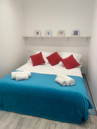 Elle comprend un grand lit avec des oreillers rouges et blancs. dans l'établissement Halcatibou, à Grimaud