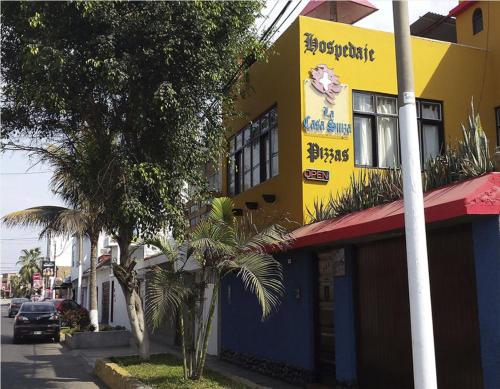 a yellow and blue building on the side of a street at La Casa Suiza in Huanchaco