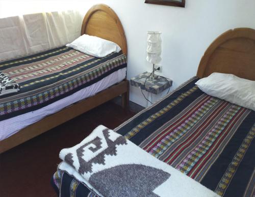 two beds sitting next to each other in a room at La Casa Suiza in Huanchaco