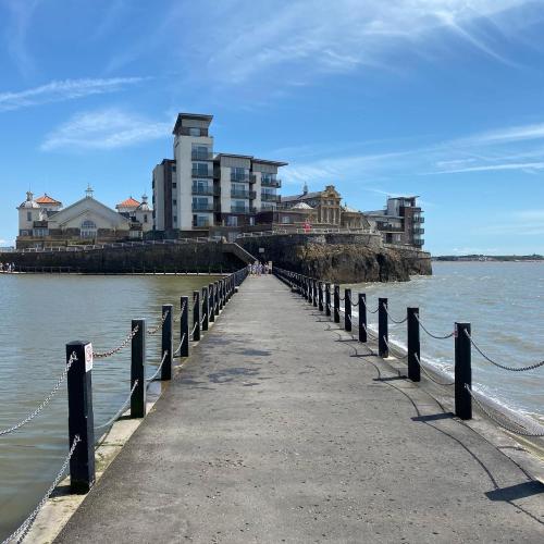 a pier leading into the water with buildings in the background at The Retreat in Weston-super-Mare