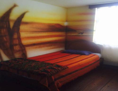 a bedroom with a bed with a painting on the wall at La Casa Suiza in Huanchaco