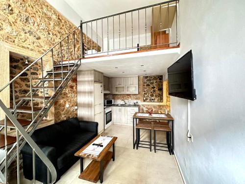 a living room with a black couch and a staircase at Lovinna Luxury Appartments in Kalymnos
