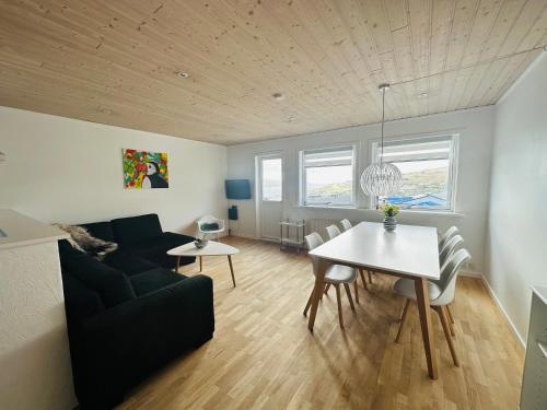 a living room with a couch and a table at Great apartment with sea view & balcony in Tórshavn