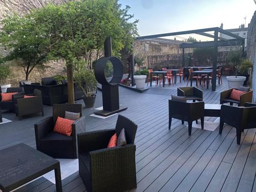 un patio avec des chaises, des tables et des tables avec des tables et des chaises dans l'établissement Hôtel De Wimereux, à Wimereux