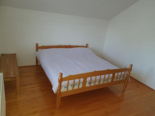 een bed met een houten frame in een kamer bij AK apartments in Kamenjača