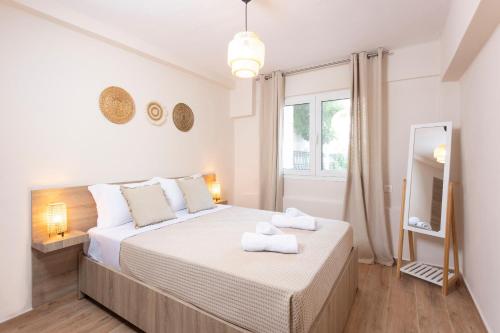 een slaapkamer met een groot bed met handdoeken erop bij Olivia Apartments in Pefkochori
