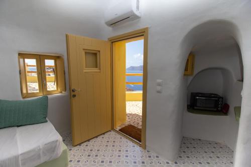 Puerta a una habitación con cama y ventana en Villa Ariadni Cave Houses in Oia, en Oia
