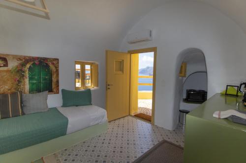 a bedroom with a bed and a yellow door at Villa Ariadni Cave Houses in Oia in Oia