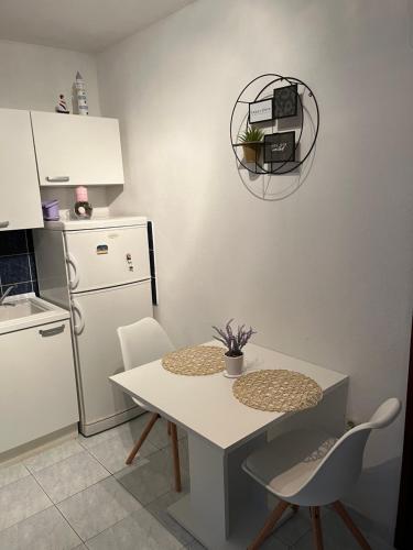 a kitchen with a white table and a white refrigerator at Apartments Despotović in Vis