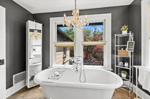 a bathroom with a large white tub and a window at German Village Serenity, Steps to Schiller Park in Columbus
