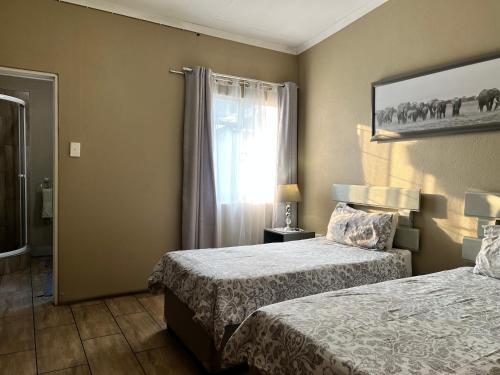 um quarto de hotel com duas camas e uma janela em khaya4u Guesthouse em Dundee
