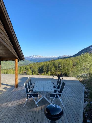 un patio con mesa y sillas en una terraza en Fjelltun Lodge, en Sogndal