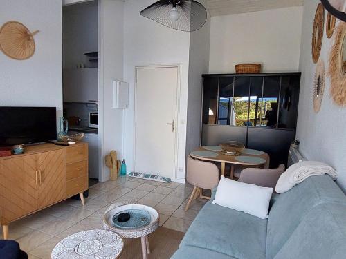 un salon avec un canapé bleu et une table dans l'établissement Appartement entre plage et forêt avec parking à Saint-Georges-de-Didonne - FR-1-550-61, à Saint-Georges-de-Didonne