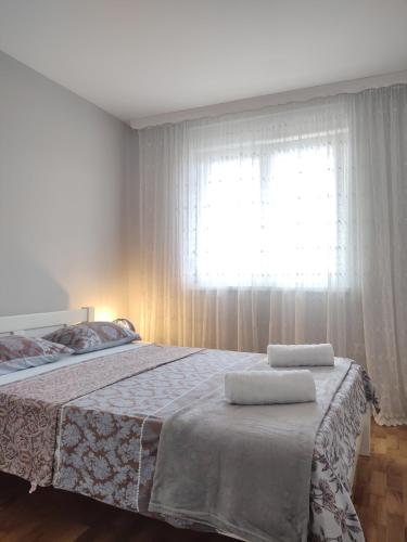 a bedroom with a bed with two towels on it at Apartment Allure in Čapljina