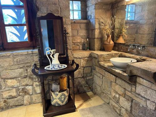 a stone bathroom with a sink and a mirror at Vila-seca, vine i desconnecta! in Aguilar de Segarra