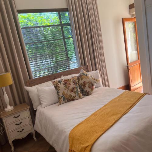 um quarto com uma cama e uma janela grande em Peaceful@Swansea In Rosebank-Parkwood em Joanesburgo
