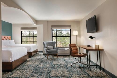 Habitación de hotel con cama, escritorio y silla en Four Points by Sheraton Raleigh Arena, en Raleigh