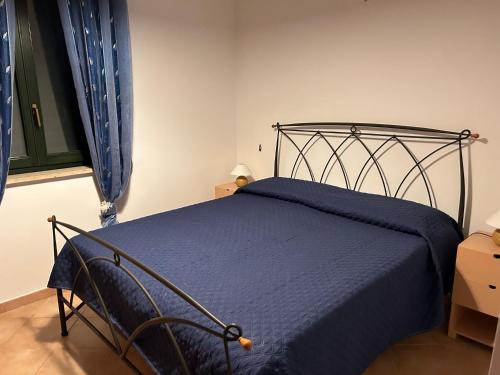 Villetta sul mare in Resort Village في كامبوفيليتْشّي دي روتْشّيلا: غرفة نوم بسرير ولحاف ازرق