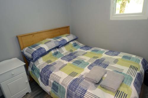 1 cama con 2 toallas en un dormitorio en Tawny Lodge en Westport