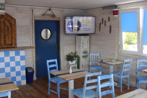 ein Restaurant mit blauen Stühlen und Tischen und einer blauen Tür in der Unterkunft K 2 in Jastrzębia Góra