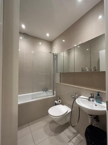 a bathroom with a toilet and a sink and a tub at Marble Arch Apartment, 2-Bedroom in London