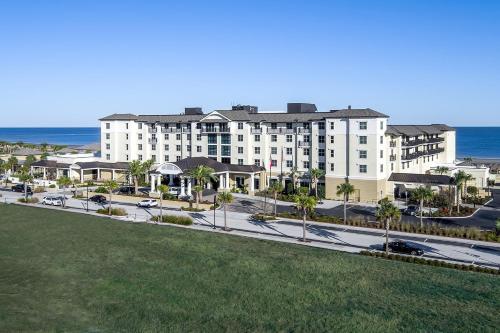 duży biały budynek na ulicy obok oceanu w obiekcie The Westin Jekyll Island Beach Resort w mieście Wyspa Jekyll