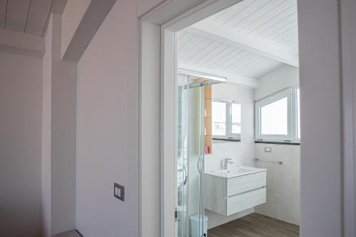 W łazience znajduje się szklana kabina prysznicowa i umywalka. w obiekcie Nauticus Guest Room w mieście Torre San Giovanni Ugento