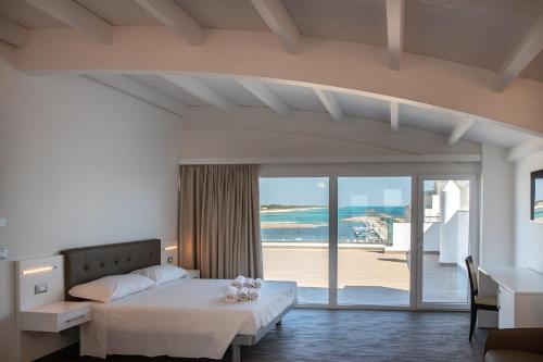 a bedroom with a bed and a view of the ocean at Nauticus Guest Room in Torre San Giovanni Ugento