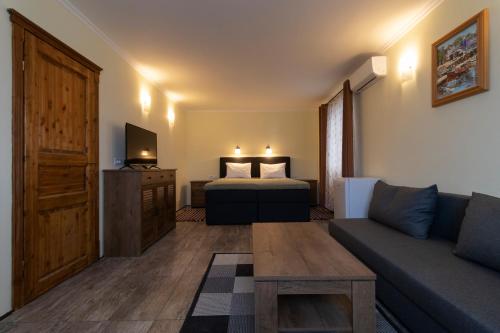 uma sala de estar com um sofá, uma cama e uma televisão em Taverna & Rooms em Sutivan