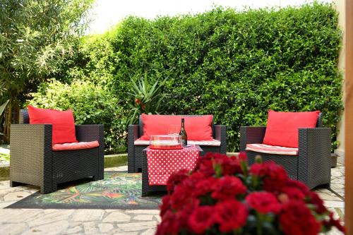 d'une terrasse avec 2 chaises et une table avec des oreillers rouges. dans l'établissement Alloggio turistico Giuly ID 3807, à Monte Porzio Catone