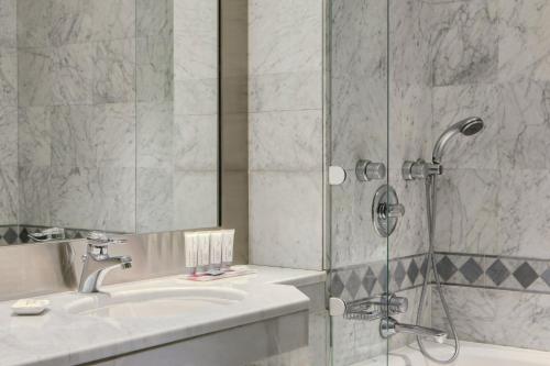 a bathroom with a sink and a shower at Le Meridien Jeddah in Jeddah