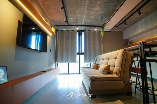 a living room with a couch and a television at Lindo Flat no Urban 750 in Tambaú