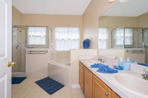 een badkamer met een wastafel, een bad en een douche bij Dahlia Reserve at Ellis Exclusive Villas in Kissimmee