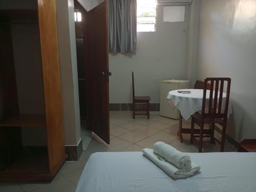 Una habitación con una mesa y una cama con toallas. en APARTHOTEL CENTRAL MACAPÁ, en Macapá
