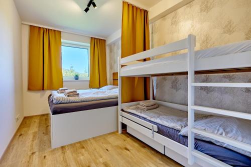 1 Schlafzimmer mit 2 Etagenbetten und einem Fenster in der Unterkunft Klínovec Suite in Loučná pod Klínovcem