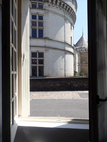 an open window looking out at a castle at L'appart' du fil in Le Lude