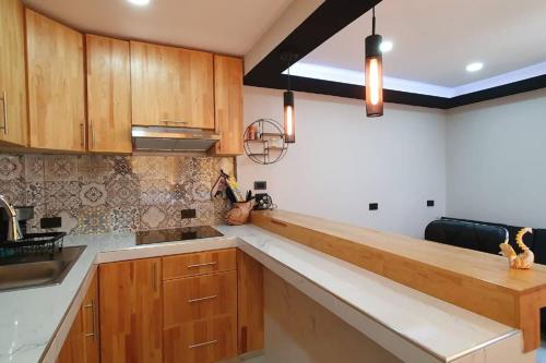 uma cozinha com armários de madeira e uma bancada em La Soley, One-Bedroom Apartment em Oaxaca de Juárez