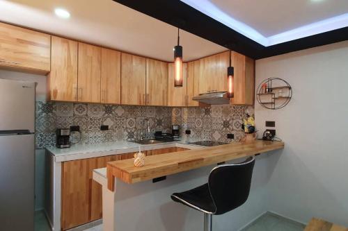uma cozinha com armários de madeira e um balcão de madeira em La Soley, One-Bedroom Apartment em Oaxaca de Juárez