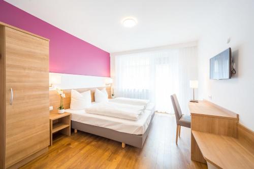 a bedroom with a bed and a desk and a tv at Hotel S16 in Munich