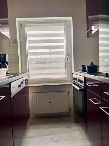 uma cozinha com uma janela, um lavatório e um fogão em 2- Zimmer Wohnung em Lehrte