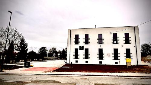 a white building with black windows on a street at Apartamenty Gliwice Staromiejska 65 in Gliwice
